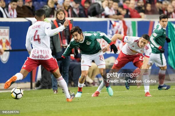 Rodolfo Pizarro of C.D. Guadalajara challenged by Sean Davis of New York Red Bulls and Tyler Adams of New York Red Bulls during the New York Red...