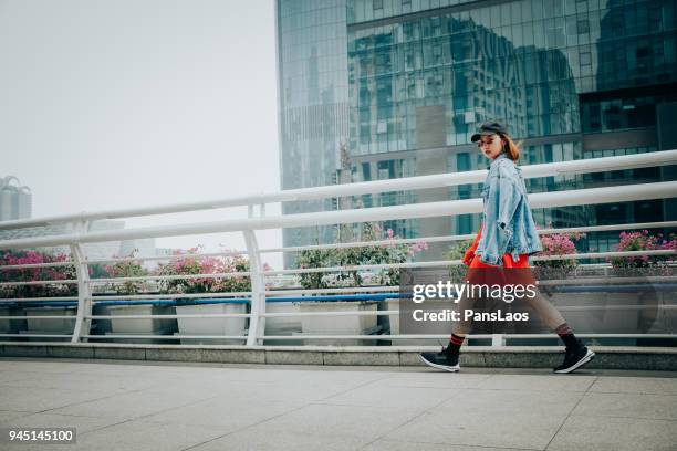 portrait of walking overpass fashion asian woman in city street - fashion urban woman stock-fotos und bilder