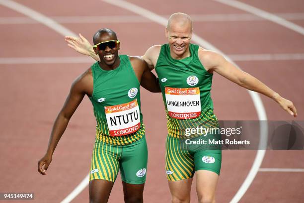 Ndodomzi Ntutu of South Africa celebrates winning gold with silver medalist Hilton Langenhoven of South Africa in the Men's T12 100m Final during...