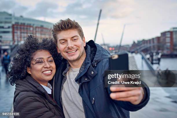 young couple taking self portrait on pier - die letzte reise photo call in hamburg stock-fotos und bilder