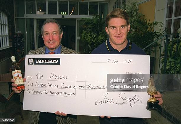 Gareth Edwards presents Tim Horan of Australia with his Famous Grouse player of the tournament cheque during the Rugby Union World Cup 1999 Famous...