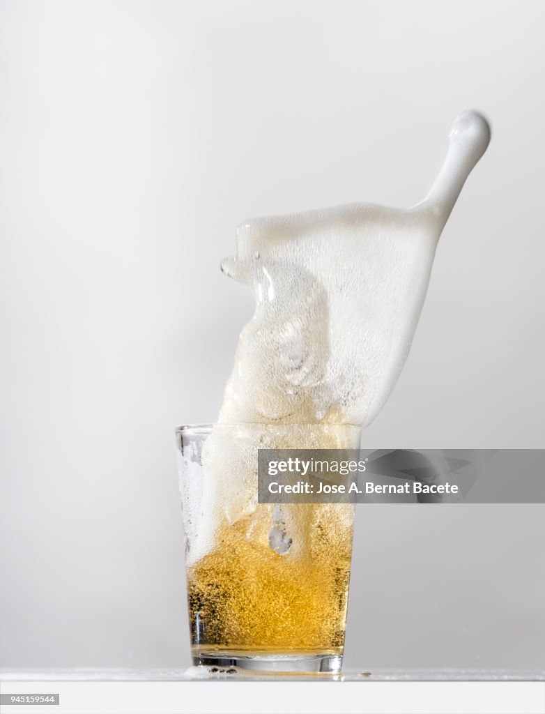 Impact of a glass with beer that falls down on the table.