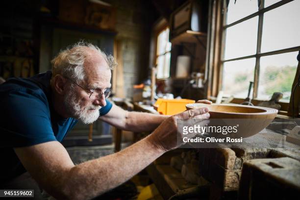 carpenter in workshop working on a wooden bowl - craft stock-fotos und bilder