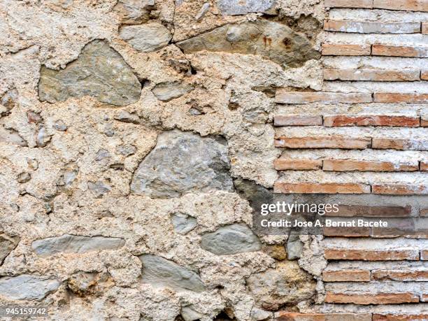 full frame of a facade of a stone wall with bricks ancient. high resolution photography. - adobe texture stockfoto's en -beelden