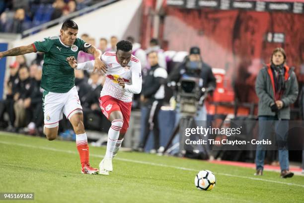 Derrick Etienne of New York Red Bulls is challenged by Carlos Salcido of C.D. Guadalajara during the New York Red Bulls Vs C.D. Guadalajara CONCACAF...