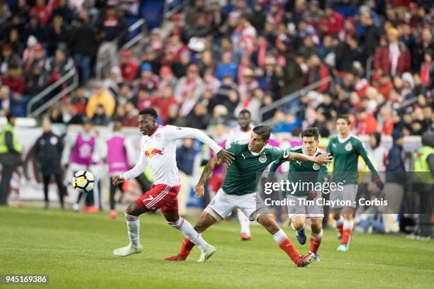 Derrick Etienne of New York Red Bulls is challenged by Carlos Salcido of C.D. Guadalajara during the New York Red Bulls Vs C.D. Guadalajara CONCACAF...