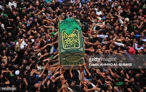 Shiite Muslim worshippers carry a symbolic casquet as they gather at the Imam Musa al-Kadhim's mosque in the Iraqi capital's northern district of...