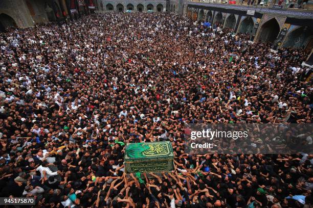 Shiite Muslim worshippers carry a symbolic casquet as they gather at the Imam Musa al-Kadhim's mosque in the Iraqi capital's northern district of...