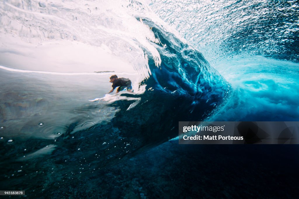 Man catches a wave on surf board