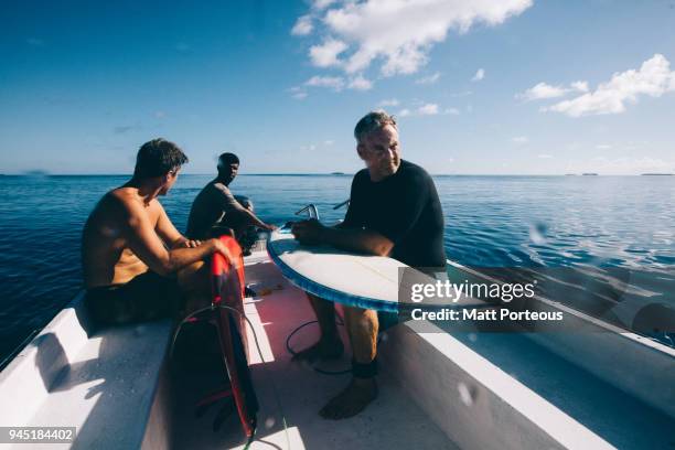 surfers head out to sea - waste wealth stock pictures, royalty-free photos & images