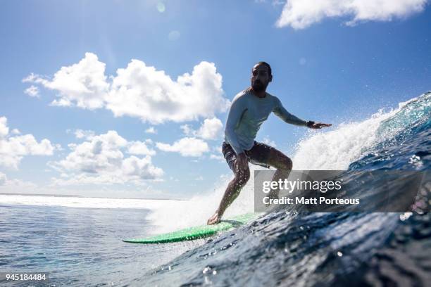 surfer catches a wave - duck dive stock pictures, royalty-free photos & images