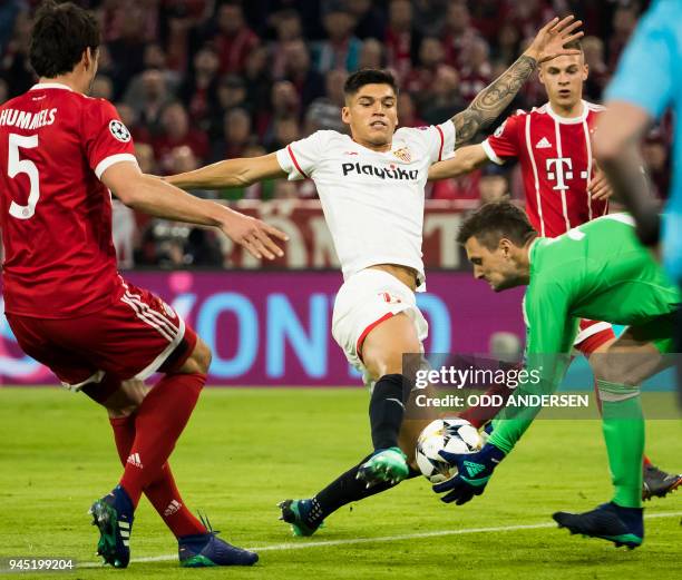 Bayern Munich's German goalkeeper Sven Ulreich snaps the ball from the foot of Sevilla's Argentinian midfielder Joaquin Correa during the UEFA...