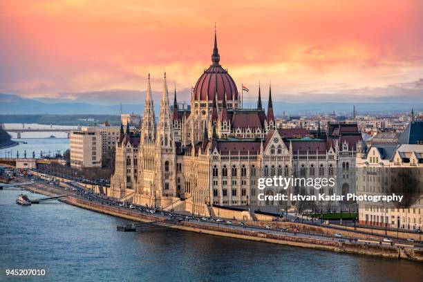 the hungarian parliament on the danube river at sunset in budapest, hungary - budapest stock-fotos und bilder