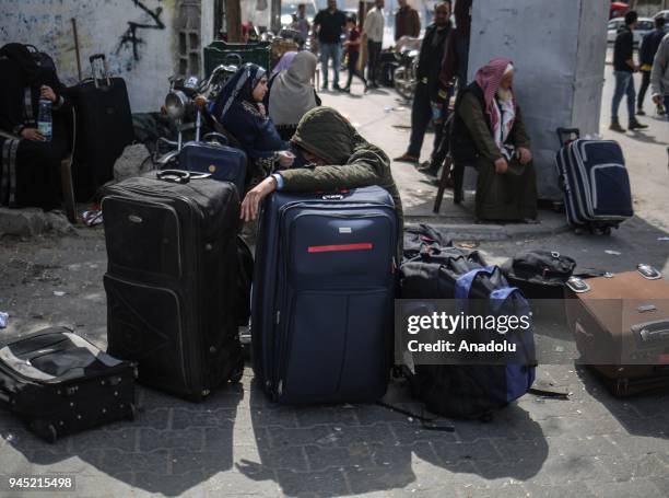 Palestinians wait with their belongings to cross to Egypt with buses following the opening of Rafah border gate in Khan Yunis, Gaza on April 12,...