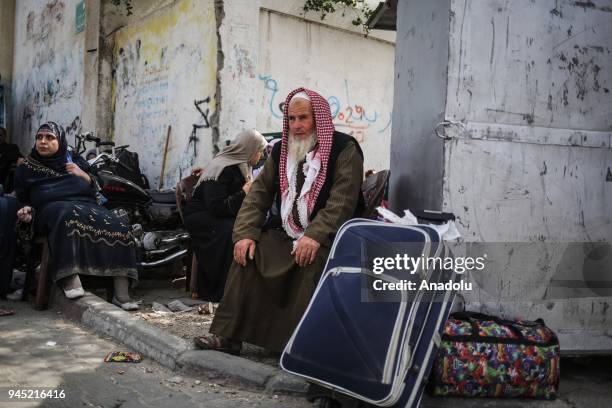 Palestinians wait with their belongings to cross to Egypt with buses following the opening of Rafah border gate in Khan Yunis, Gaza on April 12,...