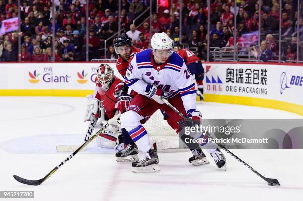 Jimmy Vesey of the New York Rangers and Brett Connolly of the Washington Capitals battle for the puck in the second period at Capital One Arena on...