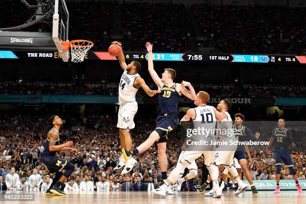 Omari Spellman of the Villanova Wildcats and Jon Teske of the Michigan Wolverines compete for the ball during the first half of the 2018 NCAA Photos...