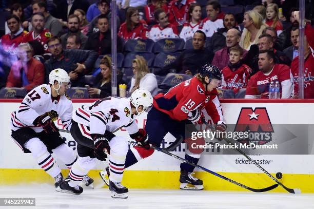 Nicklas Backstrom of the Washington Capitals controls the puck against Jan Rutta and Lance Bouma of the Chicago Blackhawks in the first period at...