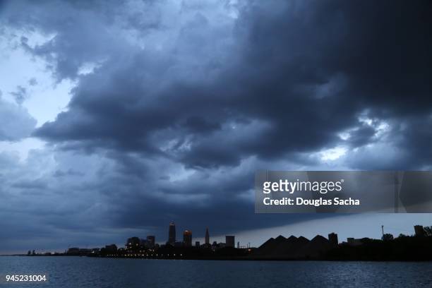 dark stormy clouds over the cleveland skyline - cleveland ohio flats stock pictures, royalty-free photos & images