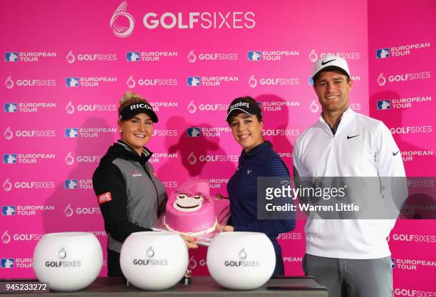Charley Hull of England and Georgia Hall of England hold the GolfSixes birthday cake while Lucas Bjerregaard of Denmark looks on after selecting for...
