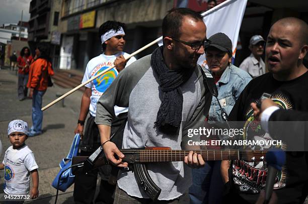 Man plays an AK-47 assault rifle that has been transformed into a guitar during the 'World March for Peace and Non-Violence' in Bogota on December...