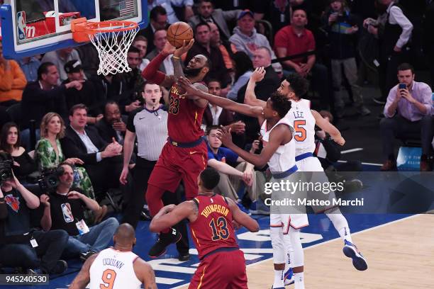 LeBron James of the Cleveland Cavaliers lays up a shot against Frank Ntilikina and Courtney Lee of the New York Knicks during the game at Madison...