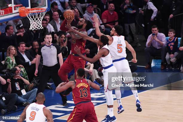 LeBron James of the Cleveland Cavaliers lays up a shot against Frank Ntilikina and Courtney Lee of the New York Knicks during the game at Madison...
