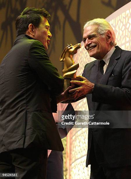 Brillante Mendoza with the Muhr AsiaAfrica Feature Best Film award for Lola onstage with actor Omar Sharif during the Closing Night Award Ceremony at...