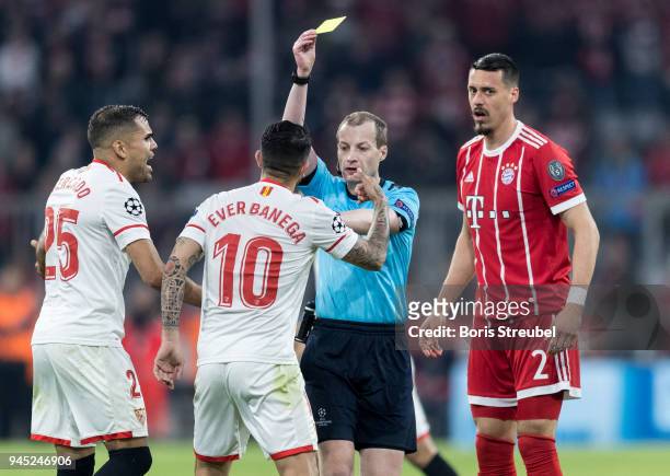 Ever Banega of FC Sevilla is shown a yellow card by referee William Collum during the UEFA Champions League Quarter Final second leg match between...