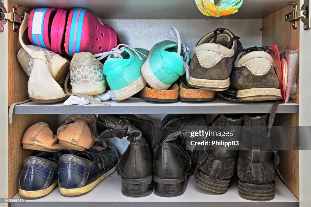 Variety of women and men shoes in a wardrobe