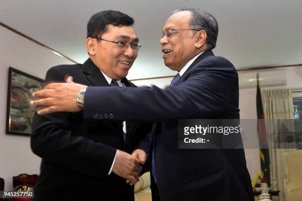 Bangladesh Foreign Minister Abul Hasan Mahmud Ali shakes hands with Myanmar Social Welfare Minister Win Myat Aye during their meeting in Dhaka on...