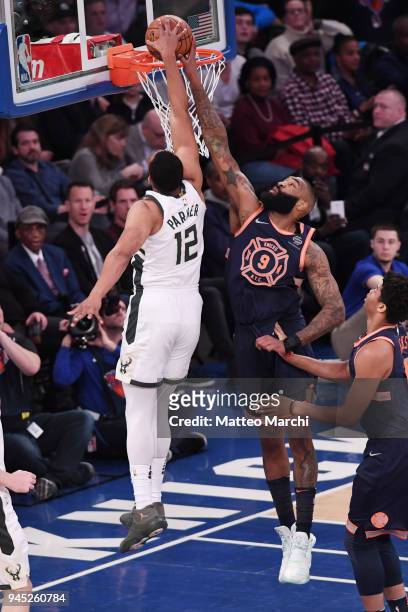 Kyle O'Quinn of the New York Knicks blocks a dunk attempted by Jabari Parker of the Milwaukee Bucks at Madison Square Garden on April 7, 2018 in New...