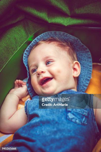 niedliche baby boy in wagen im freien im sommer - baby lachen natur stock-fotos und bilder