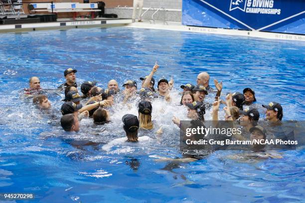 Members of the Stanford Swim and Dive team celebrate in the pool together after winning first place overall in the Division I Women's Swimming &...