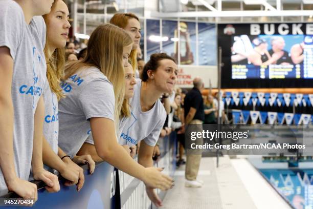 Members of the Cal swim team watch eagerly and cheer on their swimmer during the Division I Women's Swimming & Diving Championship held at the...