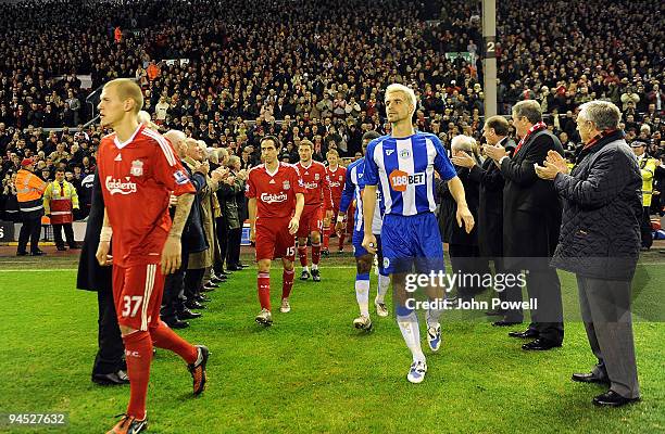 Liverpool and Wigan players walk through the legendary Shankly team during the Barclays Premier League match between Liverpool and Wigan Athletic at...