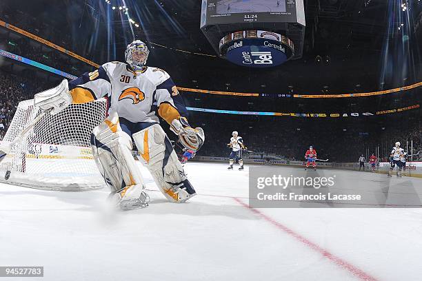 Goalie Ryan Miller of Buffalo Sabres reaches for the puck behind his net during the NHL game against the Montreal Canadiens on December 14, 2009 at...