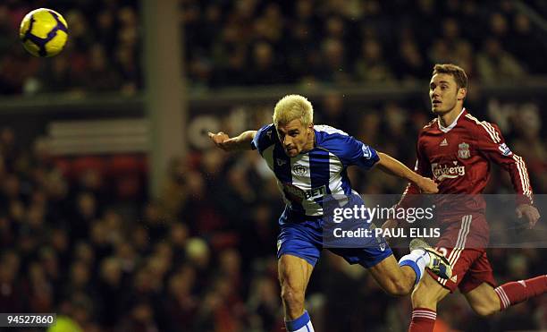 Wigan Athletic's Austrian midfielder Paul Scharner heads the ball away from Liverpool's Brazilian defender Fabio Aurelio during their English Premier...