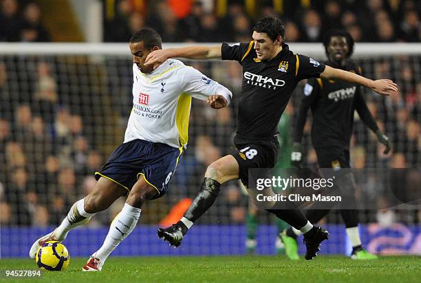 Tom Huddlestone of Spurs is challenged by Gareth Barry of Manchester City during the Barclays Premier League match between Tottenham Hotspur and...