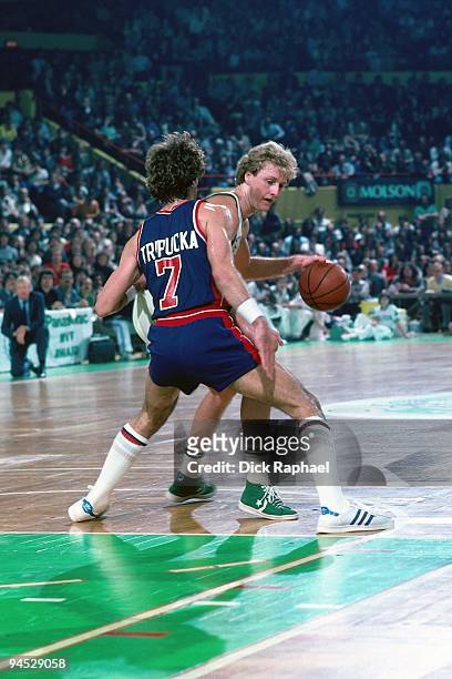 Larry Bird of the Boston Celtics posts up against Kelly Tripucka of the Detroit Pistons during a game played in 1982 at the Boston Garden in Boston,...