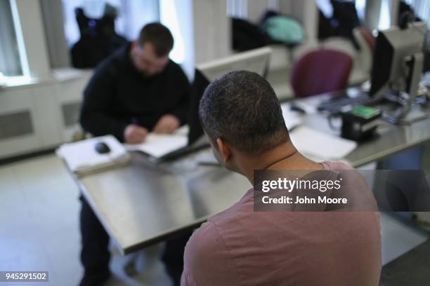 Detained undocumented immigrant waits during processing at an Immigration and Customs Enforcement , center after he was arrested on April 11, 2018 at...