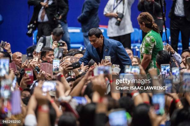 Philippines President Rodrigo Duterte shakes hands with people after an event with the Filipino community during his visit to Hong Kong on April 12,...