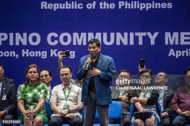 Philippines President Rodrigo Duterte sings on stage at an event with the Filipino community during his visit to Hong Kong on April 12, 2018....