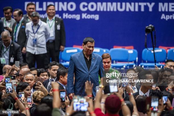 Philippines President Rodrigo Duterte poses for photos after an event with the Filipino community during his visit to Hong Kong on April 12, 2018....