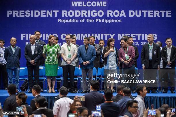 Philippines President Rodrigo Duterte stands on stage with other delegates after arriving at an event with the Filipino community during his visit to...