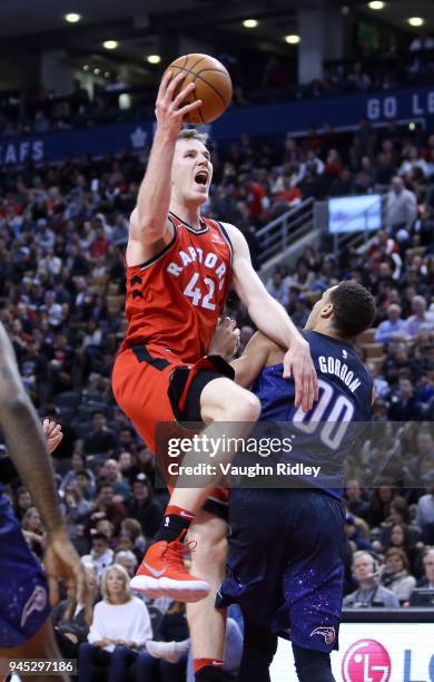 Jakob Poeltl of the Toronto Raptors shoots the ball as Aaron Gordon of the Orlando Magic defends during the second half of an NBA game at Air Canada...