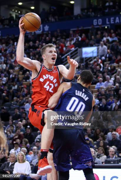 Jakob Poeltl of the Toronto Raptors shoots the ball as Aaron Gordon of the Orlando Magic defends during the second half of an NBA game at Air Canada...