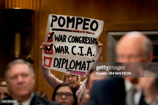 Protester from CodePink holds up a placard and shouts as US Senator Pat Roberts , R-Kansas introduces Secretary of State nominee Mike Pompeo to...