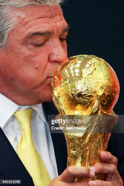 Argentinian former soccer player Hector Miguel Zelada kisses the FIFA Trophy during the FIFA Trophy Tour at Residencia Oficial de Los Pinos on April...