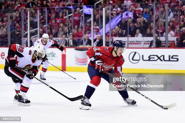 Dmitry Orlov of the Washington Capitals controls the puck against Johnny Oduya of the Ottawa Senators in the first period at Capital One Arena on...
